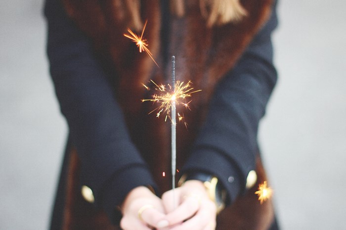 Woman holding a sparkler with bokeh effect