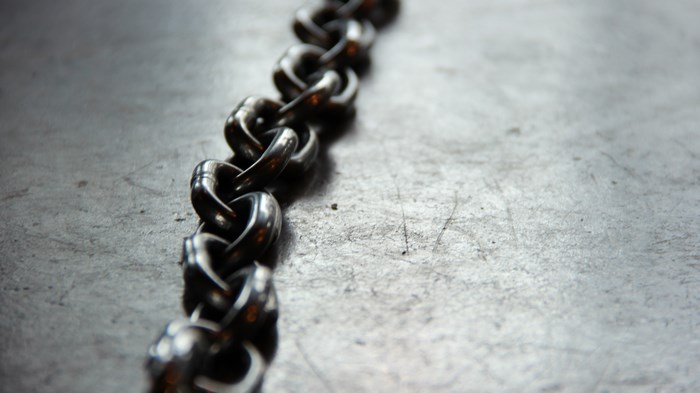 Close up of a metal chain on a textured surface