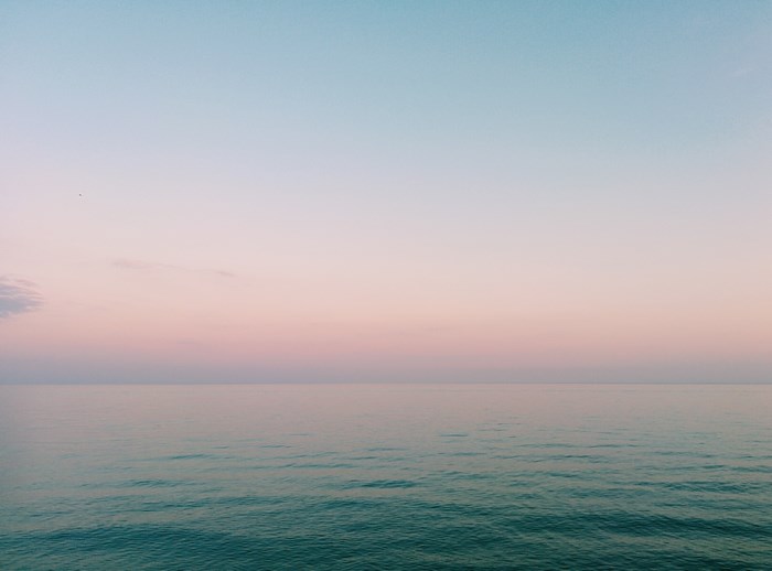 Ocean horizon with pastel sky at sunset