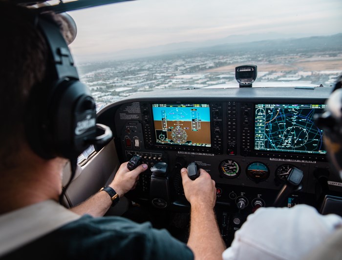 Pilots in a cockpit flying over a city