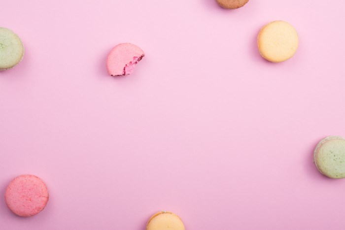 Pink and green macarons on a pink background