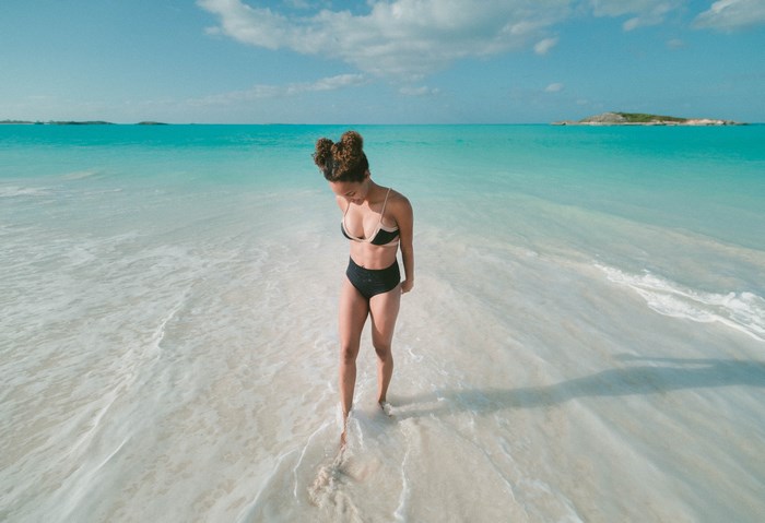 Woman in bikini walking on a tropical beach