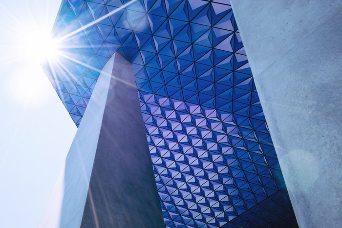 Geometric glass roof with sun flare and concrete columns