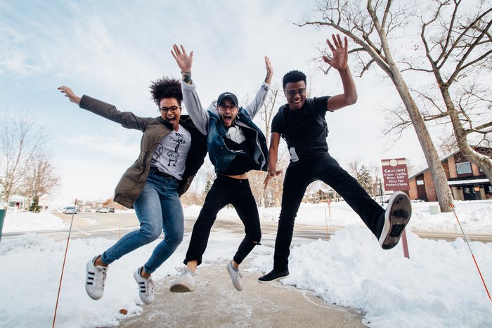 Three friends jumping in the snow