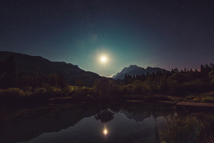 Starry night over Zelenci mountains and lake in Slovenia