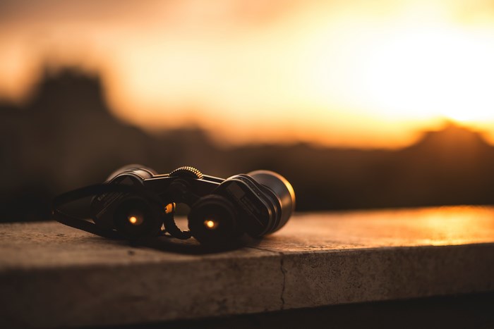 Binoculars on a ledge at sunset