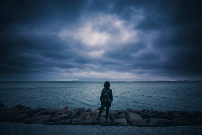 Solitary Woman Looking Out at Moody Overcast Sea