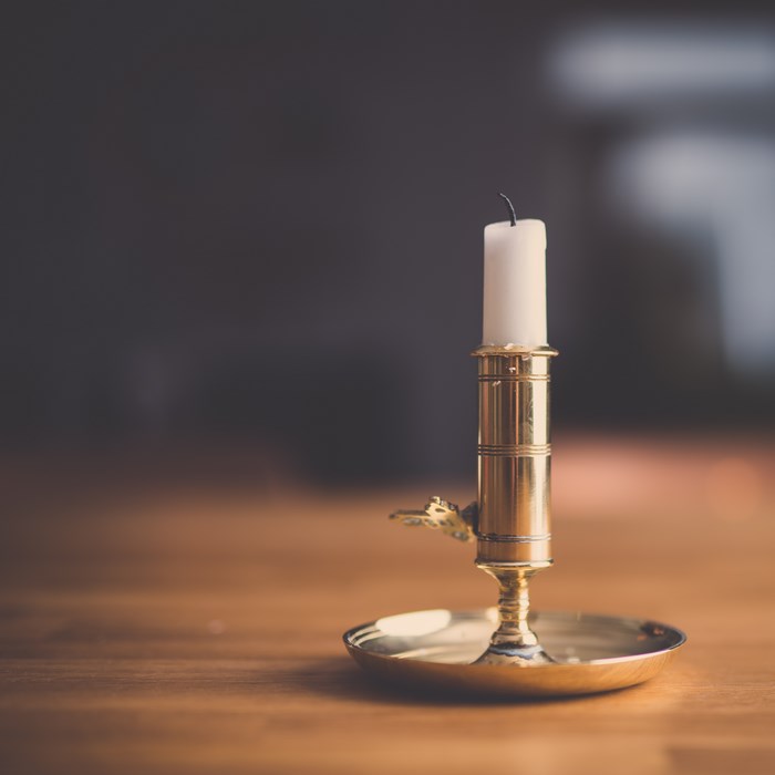 Gold Candle Holder with White Candle on Wooden Table
