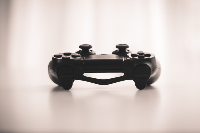 Black PlayStation Controller on a White Surface