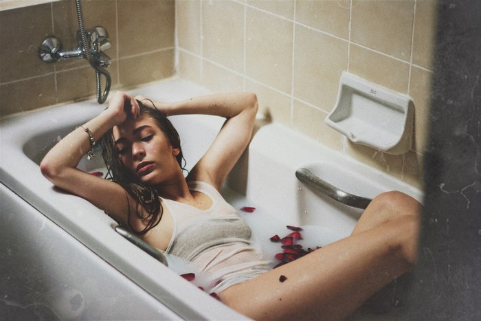 Woman relaxing in a bathtub with rose petals