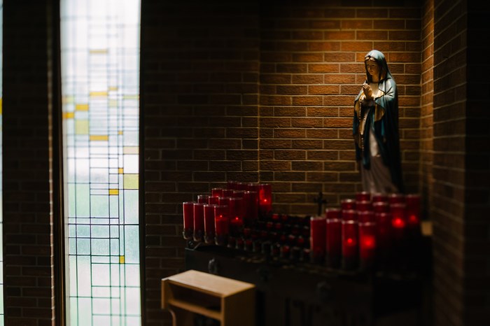 Statue of Mary with candles in a church