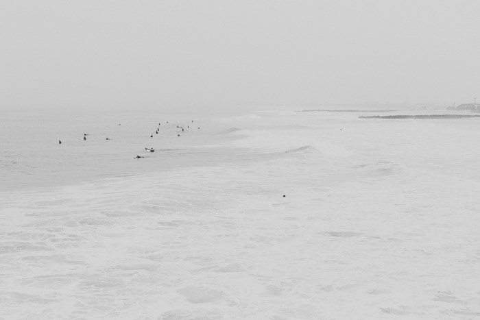 Surfers in the Ocean on a Foggy Day