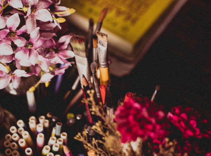 Art supplies with pink flowers and a book