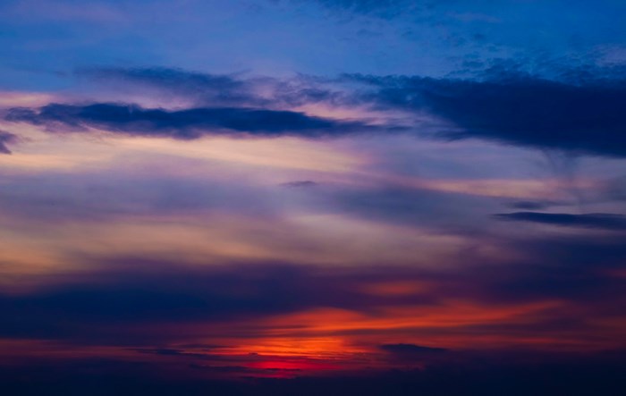 Sunset sky with clouds in blue, red, and orange hues