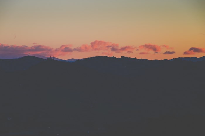 Silhouette of mountains at sunset with pink clouds