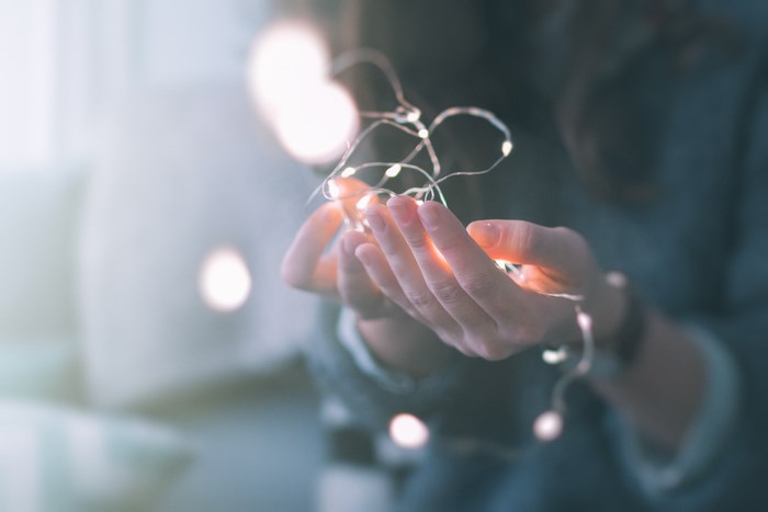 Woman holding fairy lights in cupped hands