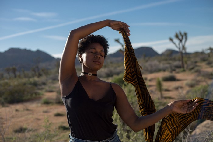 Woman dancing with a scarf in the desert