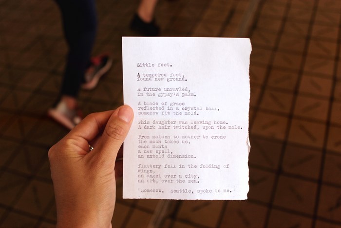 Poem titled "Little feet" held by a person