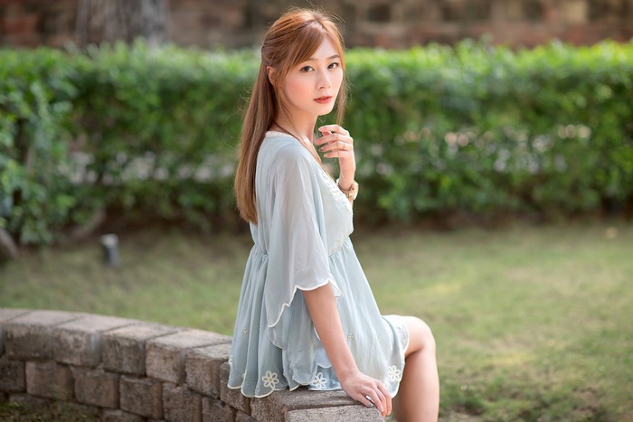 Calm Asian Woman with Long Red Hair Outdoors