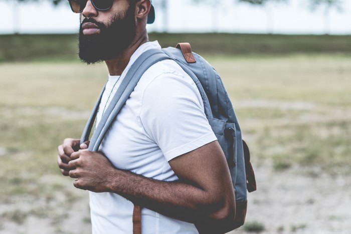Man with beard and backpack wearing sunglasses