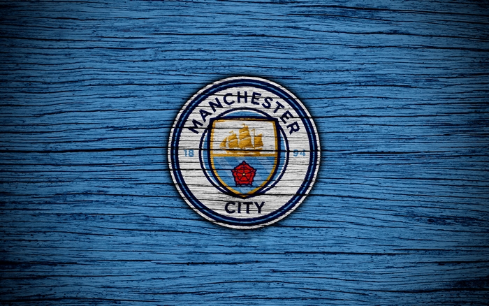 Manchester City F.C. logo on blue wooden background
