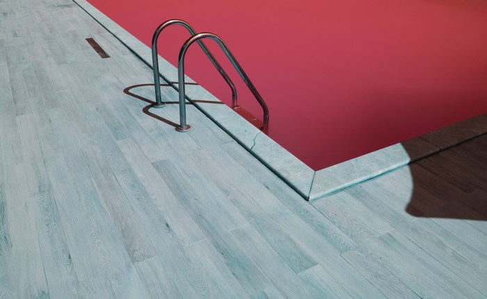 Red pool with a ladder and wooden deck