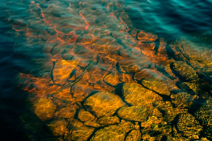 Sunlight on rocks under clear water