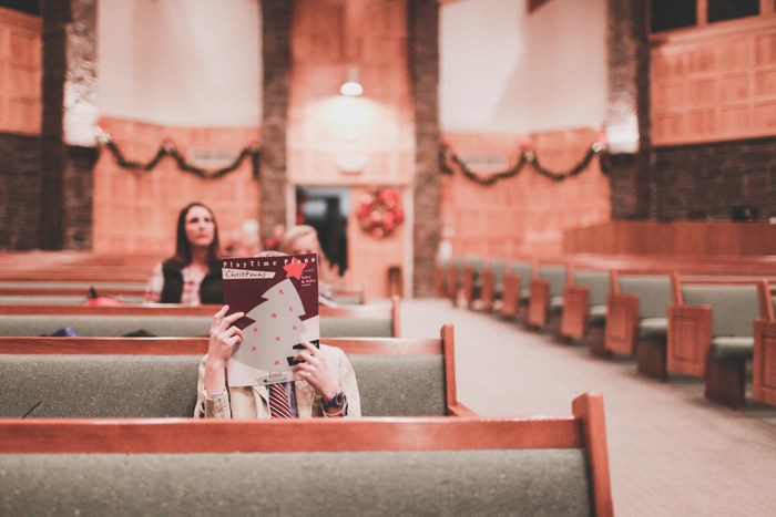 Boy Hiding Face Behind Christmas Piano Book in Church
