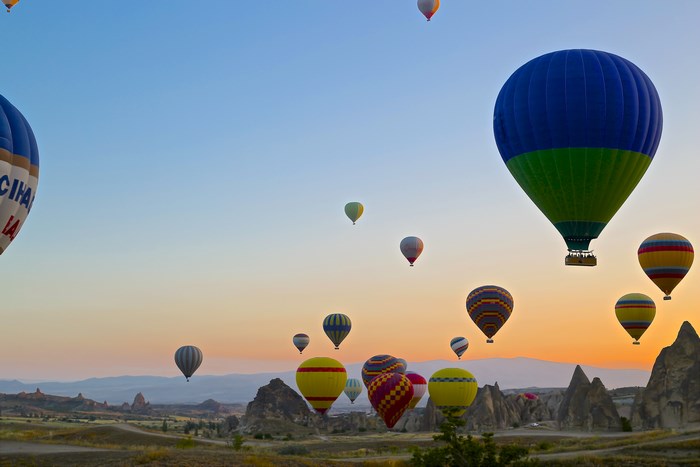Hot air balloons flying over Cappadocia at sunset