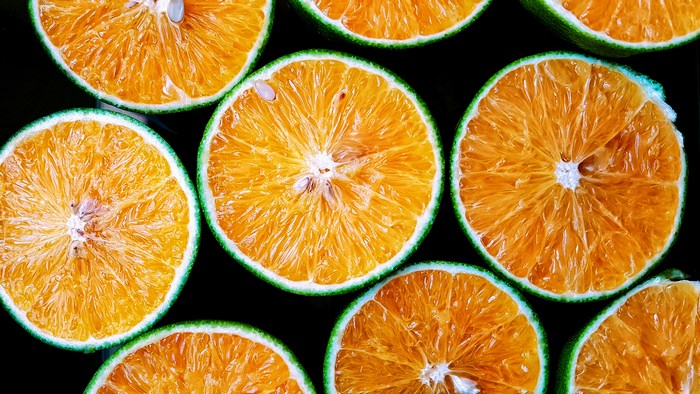 Close-up of sliced oranges with green rind