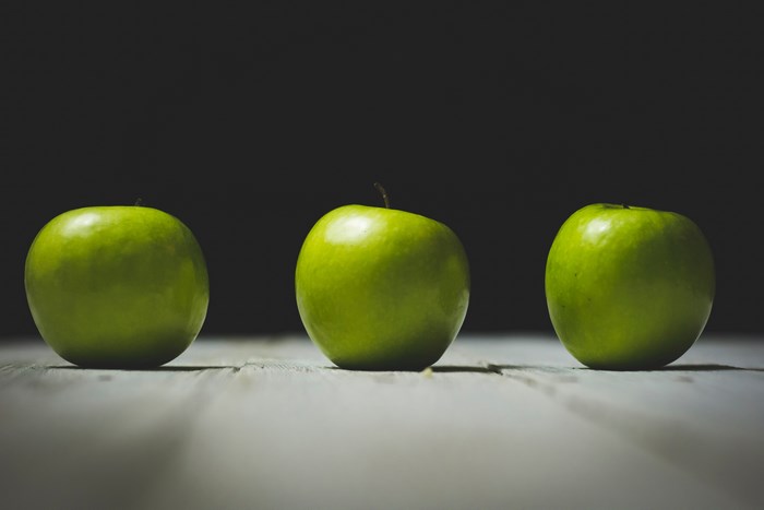 Three green apples on a wooden table