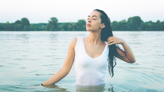 Woman in white top standing in the Danube river