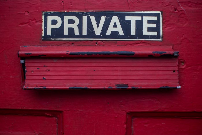 Red door with a "PRIVATE" sign and mailbox