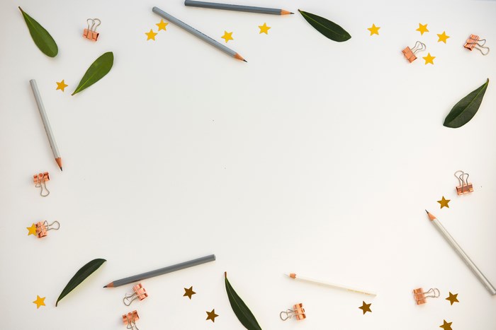 Flat lay of pencils, leaves, and star confetti