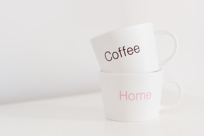 Two white mugs stacked, one with "coffee" and one with "home"