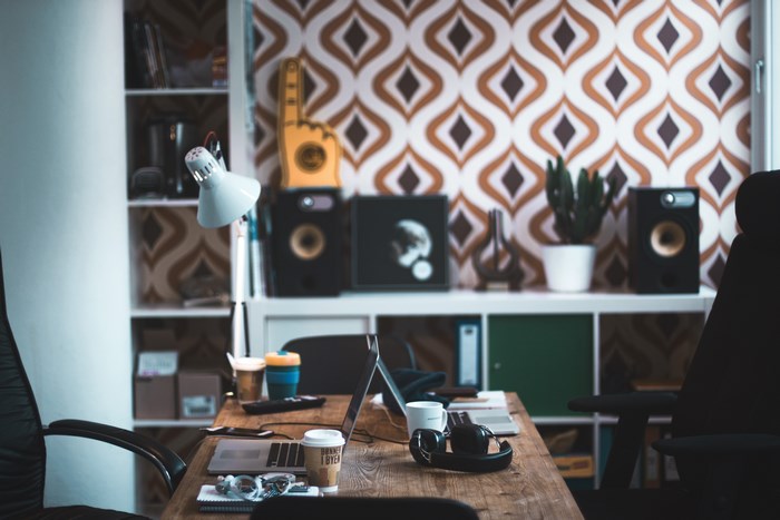 Office desk with laptop, coffee, and speakers