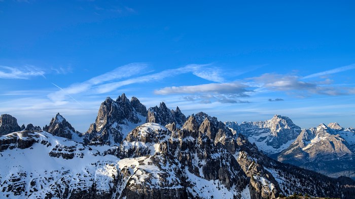 Snow-covered mountain range under a blue sky