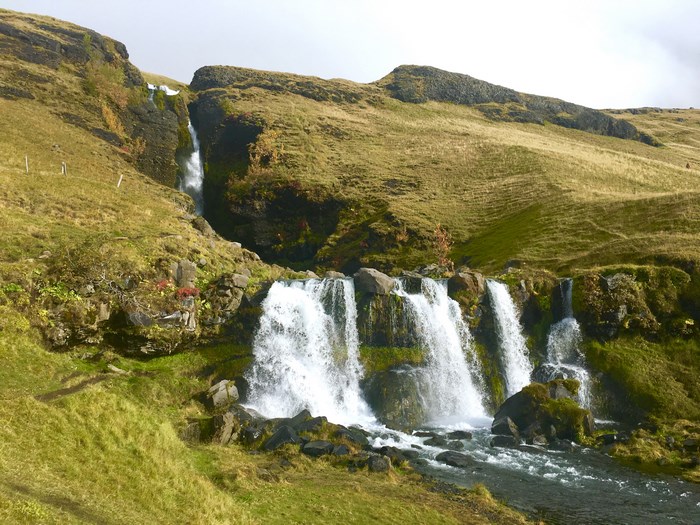 Waterfall cascading down a grassy hillside
