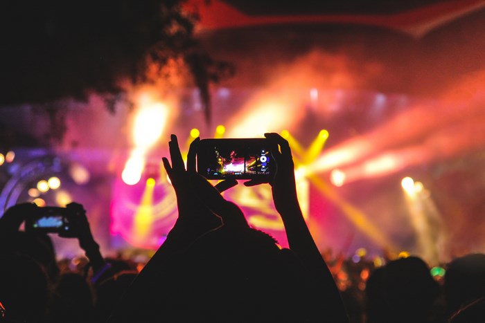Person filming a concert with a smartphone