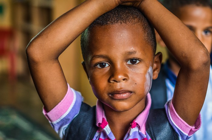 Boy with hands on head in school