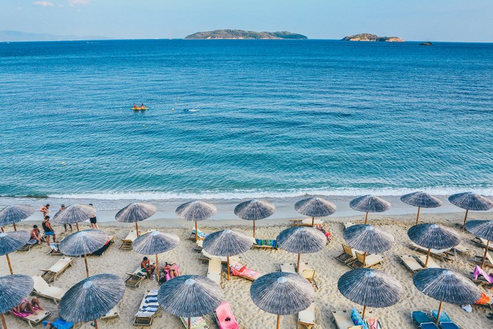 Beach with umbrellas, loungers, and people by the sea