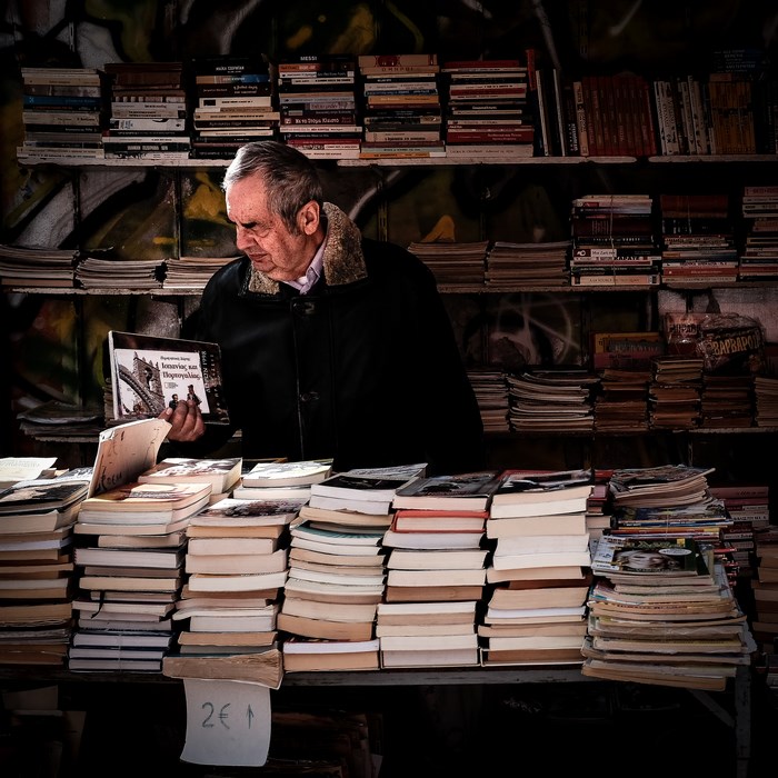 Man browsing books at a street bookstore in Athens