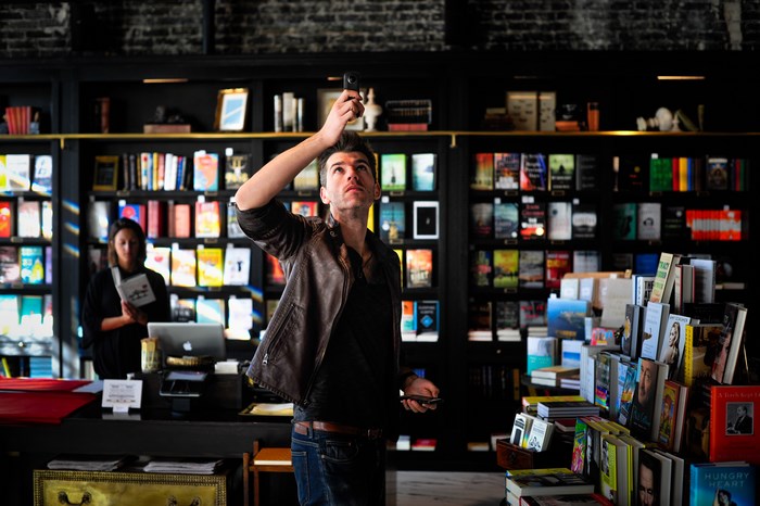 Man holding Ricoh Theta in a bookstore