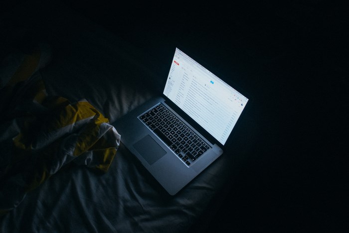 MacBook laptop on a bed at night