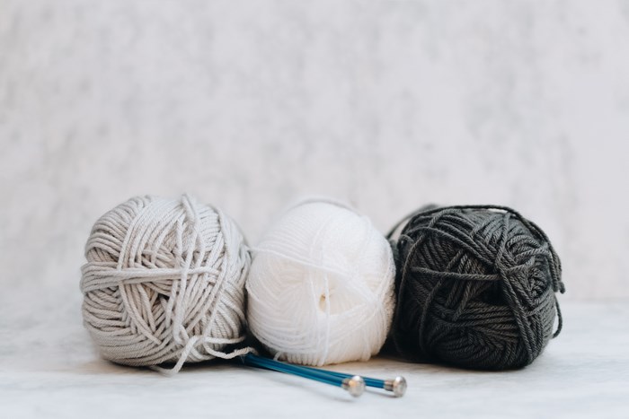 Three balls of yarn with knitting needles