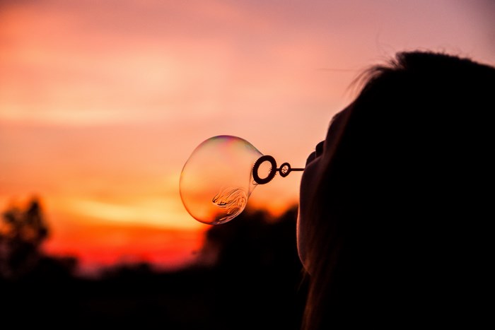 Woman Blowing Bubble at Colorful Sunset