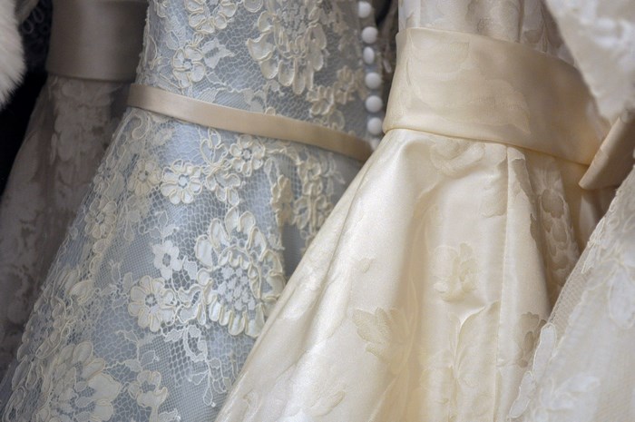 Close-up of wedding dresses with lace and sashes