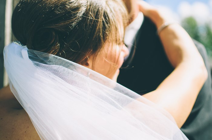 Bride and groom embracing with veil