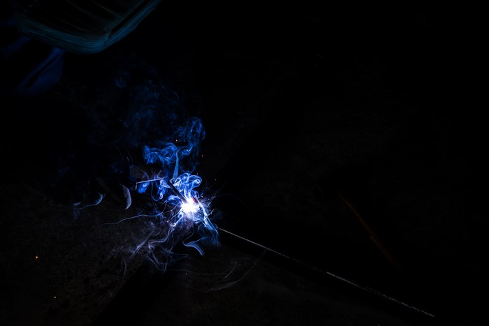 Welding torch with blue smoke and sparks