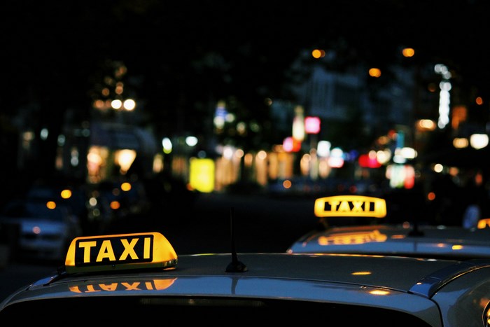 Night city street with illuminated taxi signs